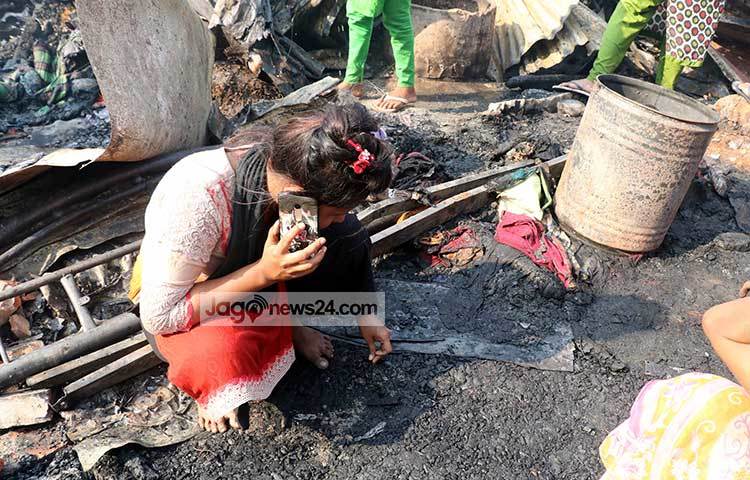 নিজেদের আশ্রয়স্থল পুড়ে যাওয়ার সংবাদ ফোনে জানাচ্ছে বস্তির এই মেয়েটি। ছবি : বিপ্লব দিক্ষিৎ