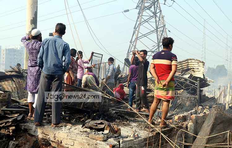 বস্তি পুড়ের যাওয়ার দৃশ্য মোবাইল ফোনের ক্যামেরায় ধারণ করছেন একজন। ছবি : বিপ্লব দিক্ষিৎ