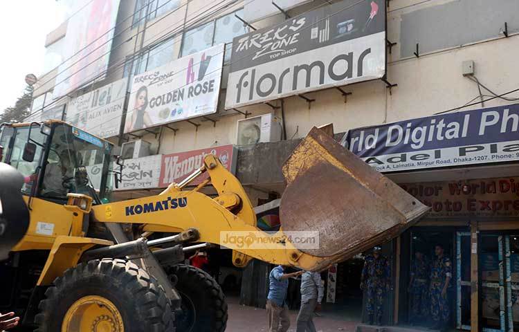 বৃহস্পতিবার অভিযানের শুরুতে আসাদগেট এলাকার কালার ওয়ার্ল্ড ডিজিট এক্সপ্রেস (ডিজিটাল স্টুডিও), ওয়াল্টন শো রুম (জামান ইঞ্জিনিয়ারিং) প্রতিষ্ঠানগুলোর নামফলক বাংলার পরিবর্তে ইংরেজিতে থাকায় তা অপসারণ করা হয় পাশাপাশি প্রতিষ্ঠানগুলোকে ৫ হাজার টাকা করে জরিমানা করা হয়। ছবি : বিপ্লব দিক্ষিৎ
