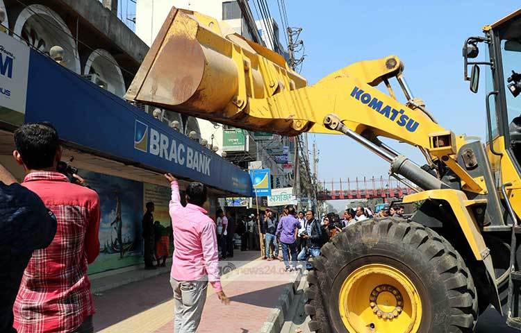বুলডোজার দিয়ে নামফলক তুলে ফেলা হচ্ছে। ছবি : বিপ্লব দিক্ষিৎ