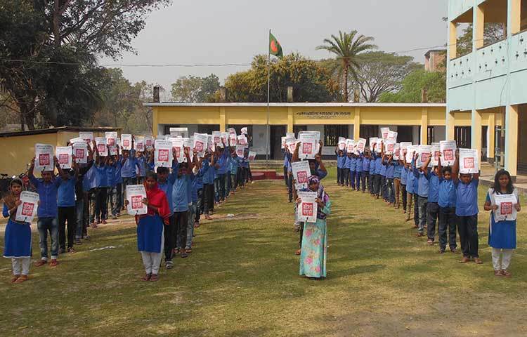 স্কুলের ছাত্র-ছাত্রীরা ‘জাতিসংঘে বাংলা চাই’ শীর্ষক পোস্টার প্রদর্শন করছেন। ছবি : হাফিজুল নিলু