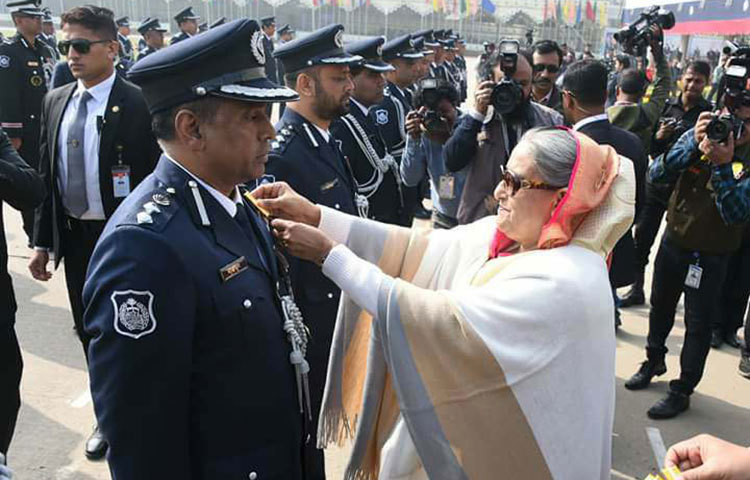 প্রধানমন্ত্রী শেখ হাসিনা ব্যাচ পরিয়ে দিচ্ছেন।