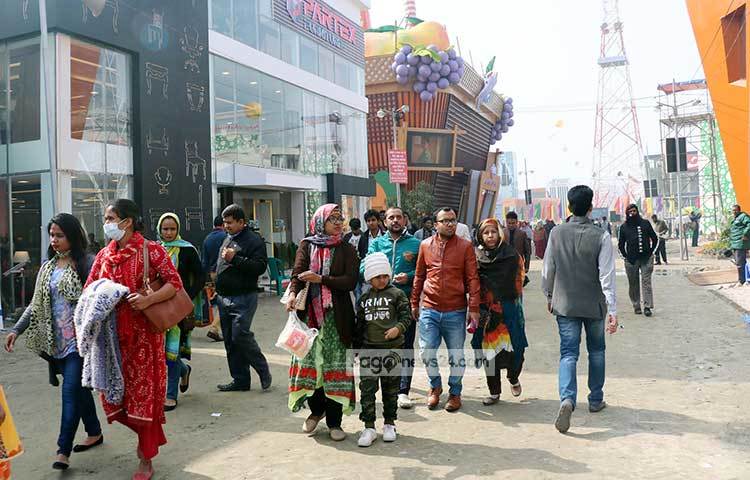 শীতে জবুথবু হয়ে মেলার মাঠে হাঁটছেন আগতরা। প্রচণ্ড শীতের কারণে মেলায় মানুষের উপস্থিতি কম। ছবি : বিপ্লব দিক্ষিৎ