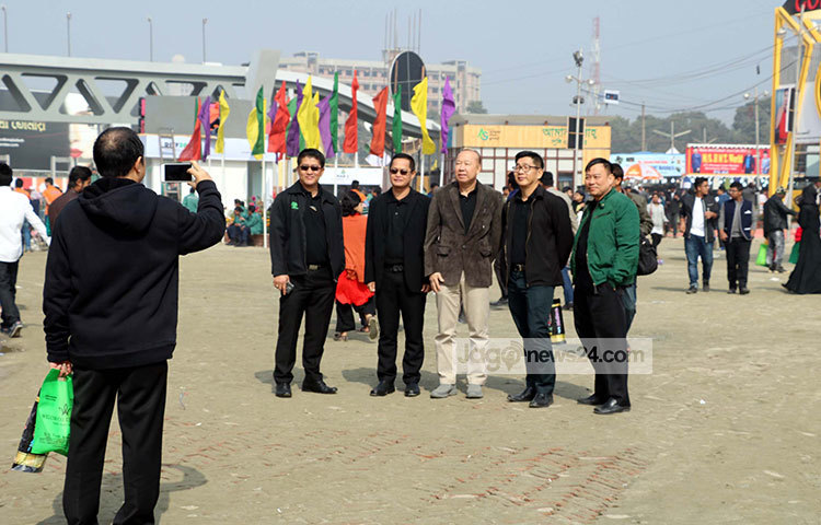 ঢিলেঢালা মেলার মধ্যে কয়েকজন বিদেশি ছবি তুলছেন। ছবি : বিপ্লব দিক্ষিৎ