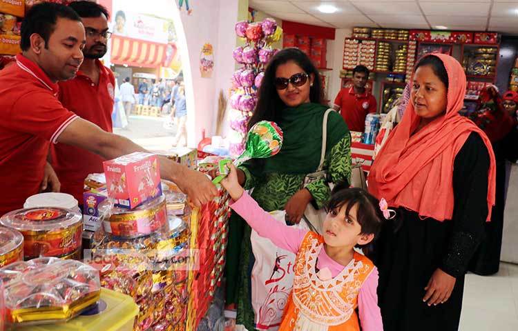 শিশুটিকে তার মা ললি পপ কিনে দিচ্ছেন। ছবি : বিপ্লব দিক্ষিৎ