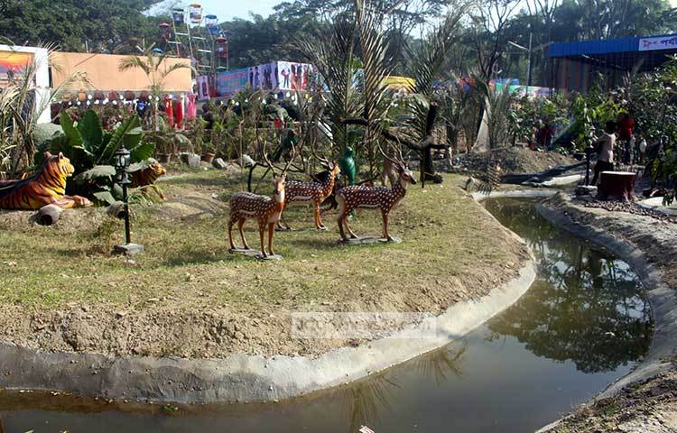 মেলার মাঠে সুন্দরবনের আবহ তৈরি করা হয়েছে। হরিণের পেছনে বাঘ ওৎ পেতে আছে। ছবি : বিপ্লব দিক্ষিৎ