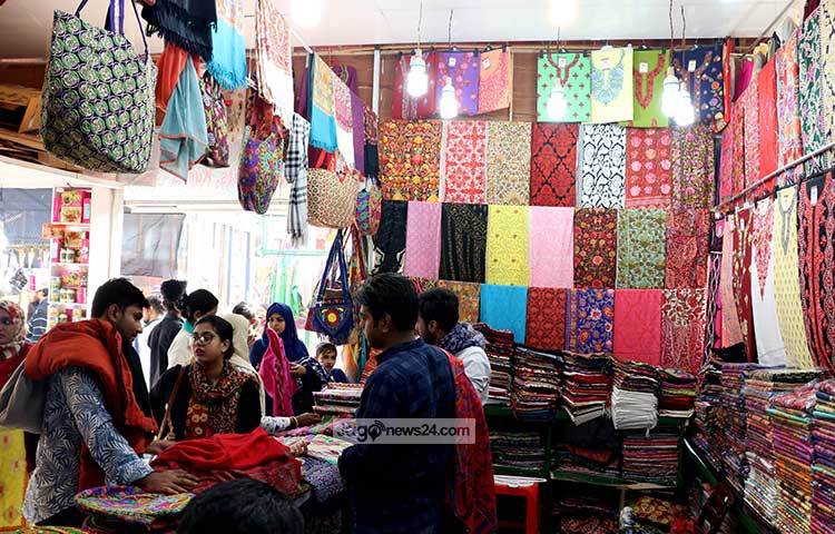 মেয়েদের জন্য থ্রি-পিচ আর থান কাপড়ের স্টল এটি। ক্রেতাদের সঙ্গে চলছে দরদাম। ছবি : মাহবুব আলম