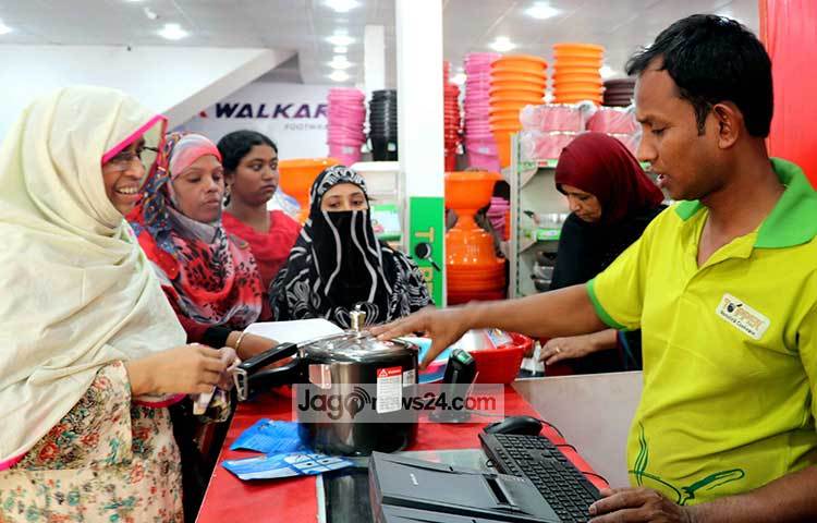 কিভাবে প্রেসার কুকার ব্যবহার করবে- তা ক্রেতাকে বুঝিয়ে দিচ্ছেন এই বিক্রেতা। ছবি : বিপ্লব দিক্ষিৎ