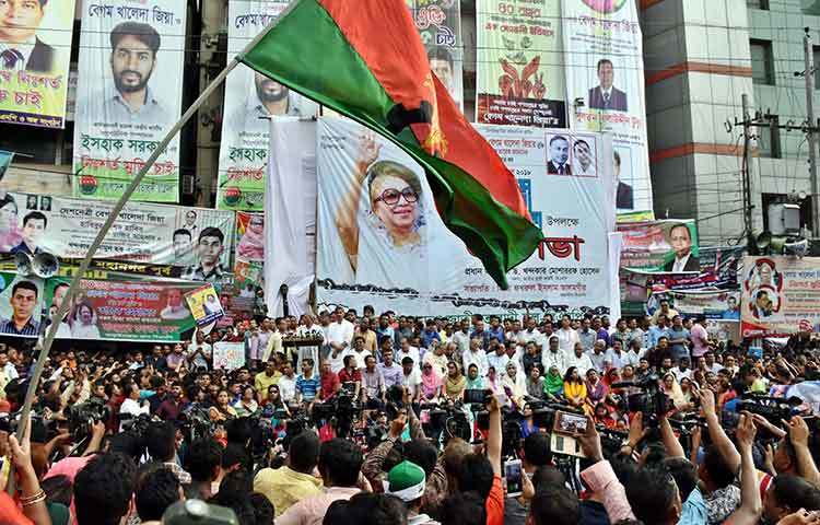 বিএনপির দলীয় পতাকা উড়াচ্ছেন এক কর্মী। জনসভার সংবাদ কভার করতে এসেছেন বিভিন্ন চ্যানেল এবং পত্রিকার সাংবাদিকরা। ছবি : বিপ্লব দিক্ষিৎ