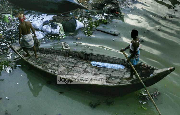 হাজারো রকমের বর্জ্য পদার্থ ফেলে এভাবেই বুড়িগঙ্গার তীর দূষিত করা হচ্ছে। কোন স্থানে নৌকা ভিড়াবে তা হয়তো ভাবছেন মাঝি। ছবি : মাহবুব আলম