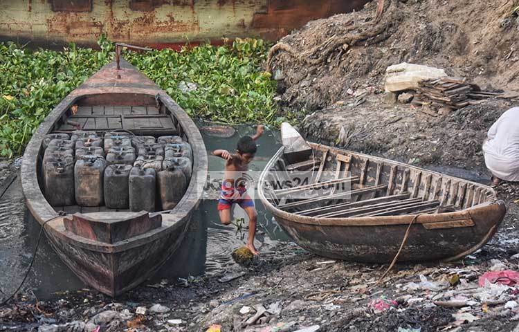 নৌকা থেকে বুড়িগঙ্গার তীরের ময়লার স্তূপের মধ্যে লাফিয়ে পড়ছে এই শিশুটি। ছবি : মাহবুব আলম