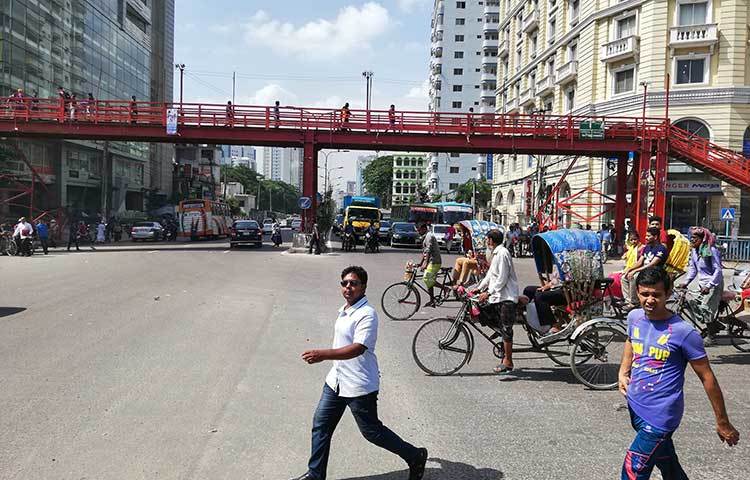 পাশেই রয়েছে ফুট ওভারব্রিজ থাকতেও তা রাস্তা পারাপারে ব্যবহার করছেন না এই পথচারীরা। ছবি : মাহবুব আলম