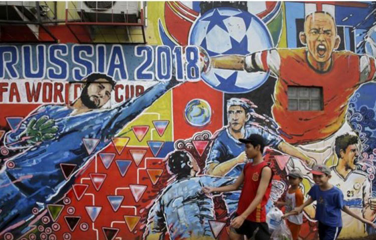 এই ছবিটি ইন্দোনেশিয়ার জাকার্তার। এখানে ফুটবলপ্রেমীরা দেওয়ালে বিশ্বকাপের পোস্টার এবং প্রিয় তারকাদের ছবি এঁকেছেন।