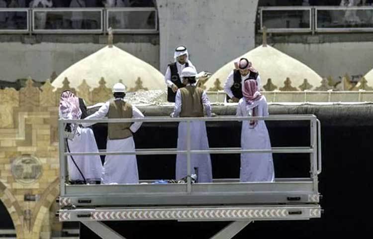 গিলাফ পরিবর্তনের কাজে ব্যস্ত কর্মীরা।