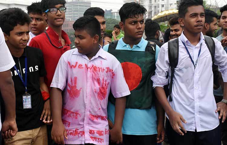 স্কুলের উইনিফর্মে এক শিক্ষার্থী ‘উই ওয়ান্ট জাস্টিস’ লিখে প্রতিবাদ জানাতে এসেছে। ছবি : বিপ্লব দিক্ষিৎ