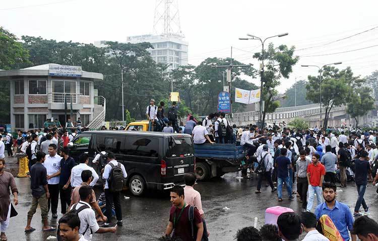 রাস্তায় বসেই প্লাকার্ডে স্লোগান লিখছে শিক্ষার্থীরা। ছবি : বিপ্লব দিক্ষিৎ