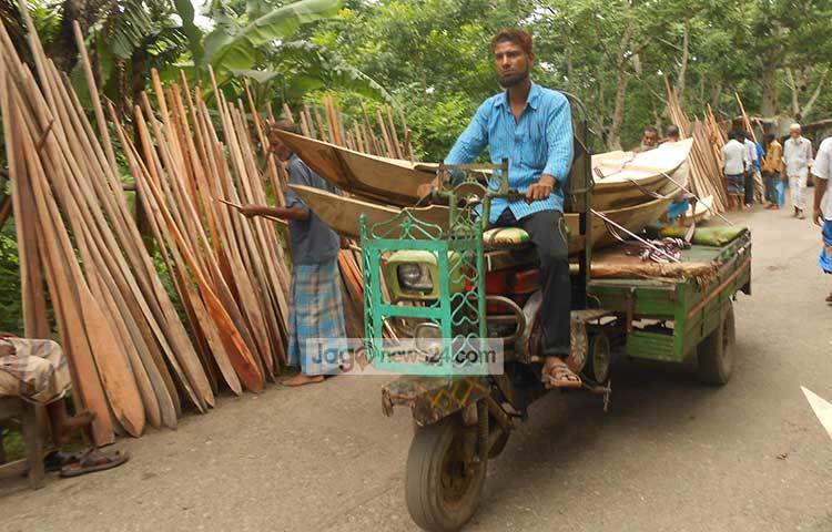 গাড়িতে করে নৌকা নিয়ে এসেছেন এক বিক্রেতা। ছবি : হাসান মামুন