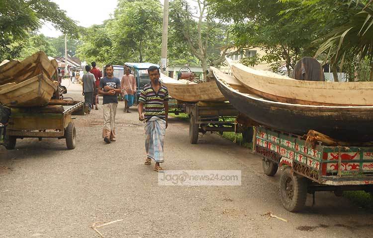 গাড়ির উপরে নৌকার হাট। ছবি : হাসান মামুন