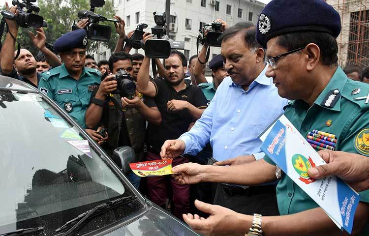 রাস্তায় চালকদের মাঝে সচেতনামূলক লিফলেট বিতরণ করছে স্বরাষ্ট্রমন্ত্রী। ছবি : বিপ্লব দিক্ষিৎ