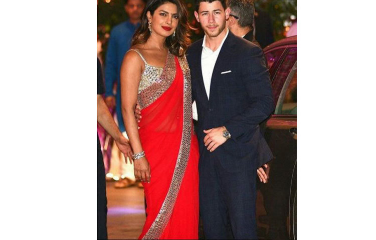 লাল শাড়িতে প্রিয়াঙ্কা এবং নিক জোনাস স্যুট পরেছেন।