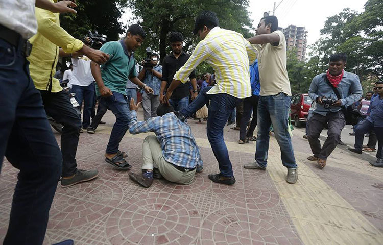 হামলাকারীরা একজন আন্দোলকরীকে মাটিতে ফেলে লাথি দিচ্ছে। ছবি : মাহবুব আলম