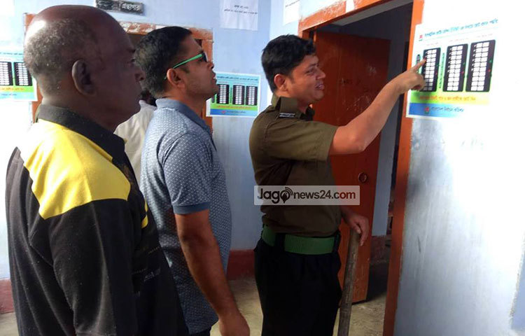 ভোটারদের ভোট দিতে নির্দেশনা দেখিয়ে দিচ্ছেন এক আনসার সদস্য।