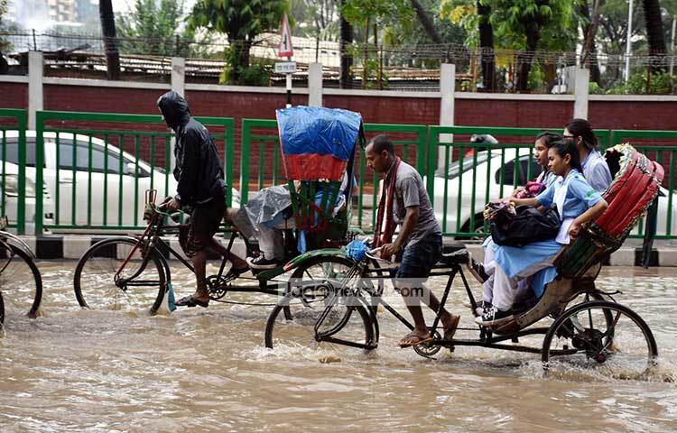 রাস্তা ডুবে যাওয়ায় সকালে স্কুলগামী শিক্ষার্থীরা বিপাকে পড়েছে। তাই অল্পপথ যেতেও রিকশায় চড়তে হচ্ছে তাদেরকে। ছবি : বিপ্লব দিক্ষিৎ