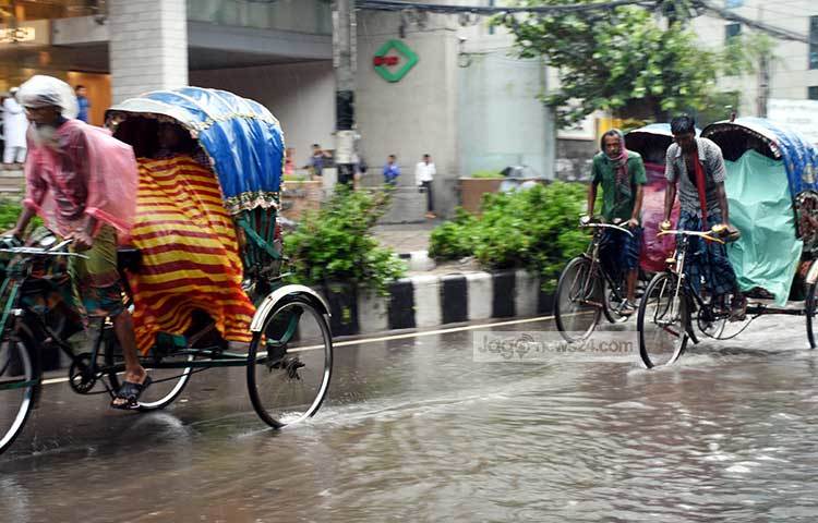আংশিক ডুবে যাওয়া রাস্তায় পলিথিন মুড়িয়ে যাত্রী নিয়ে ছুটছেন রিকশা চালকরা। ছবি : বিপ্লব দিক্ষিৎ