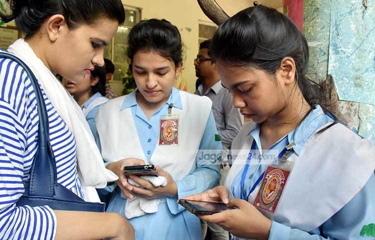 মোবাইলের মাধ্যমে ফলাফল জানার চেষ্টা করছে কয়েকজন ছাত্রী। ছবি : বিপ্লব দিক্ষিৎ