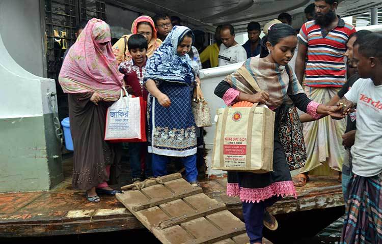 যাত্রীদের লঞ্চ থেকে নামতে সাহায্য করছেন লঞ্চকর্মীরা। ছবি : বিপ্লব দিক্ষিৎ