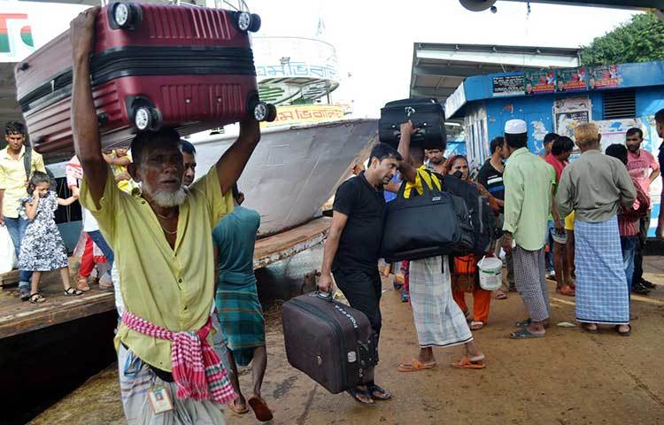 লঞ্চ থেকে যাত্রীদের মালপত্র নামিয়ে দিচ্ছে সদরঘাটের কুলিরা। ছবি : বিপ্লব দিক্ষিৎ