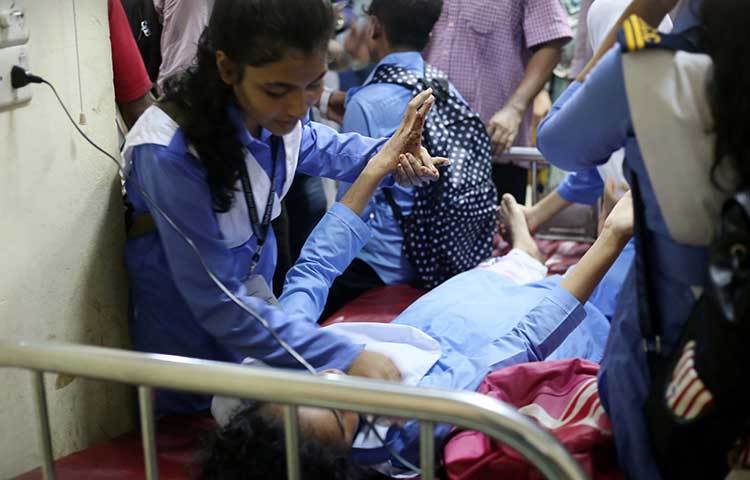 আহত এক শিক্ষার্থীকে হাসপাতালে চিকিৎসা দেয়া হচ্ছে। পাশে দাঁড়িয়ে সান্ত্বনা দিচ্ছে এক সহপাঠী।