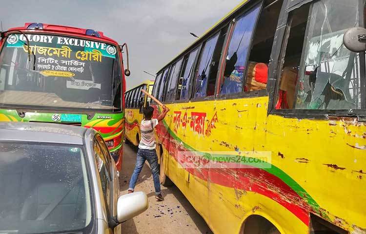 বাসের গ্লাস পিটিয়ে ভাঙছে বিক্ষুব্ধ এক শিক্ষার্থী। ছবি : মাহবুব আলম