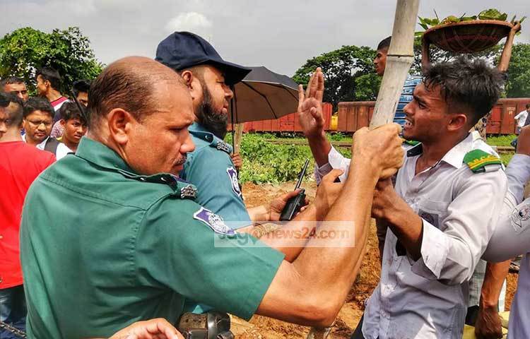 গাড়ি ভাঙচুর ঠেকাতে পুলিশ এক শিক্ষার্থীকে সরিয়ে দেয়ার চেষ্টা করছেন। ছবি : মাহবুব আলম
