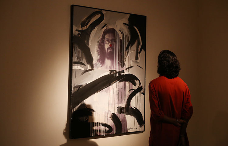 গভীর মনোযোগে ছবি দেখছেন একজন দর্শনার্থী। ছবি : মাহবুব আলম