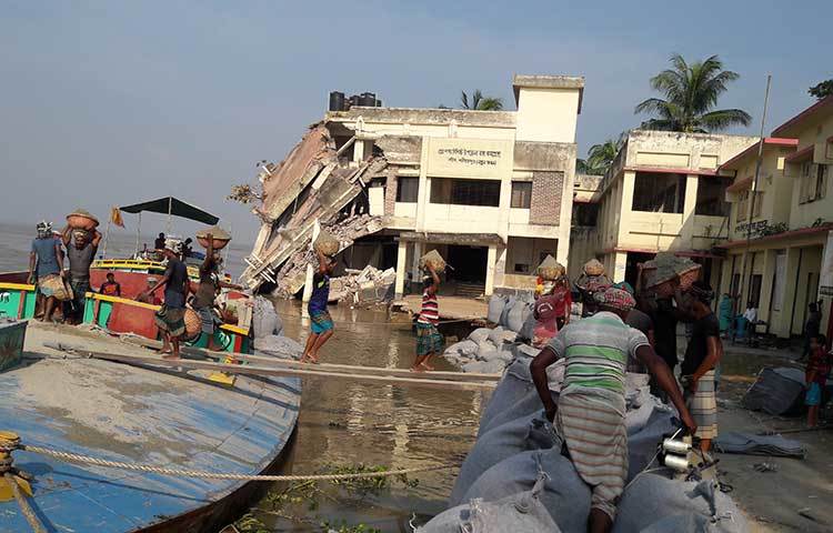 নদী ভাঙন প্রতিরোধে নেয়া হচ্ছে ব্যবস্থা। শ্রমিকরা ভাঙন এলাকায় বালুর বস্তা ফেলছে। ছবি : মো. ছগির হোসেন