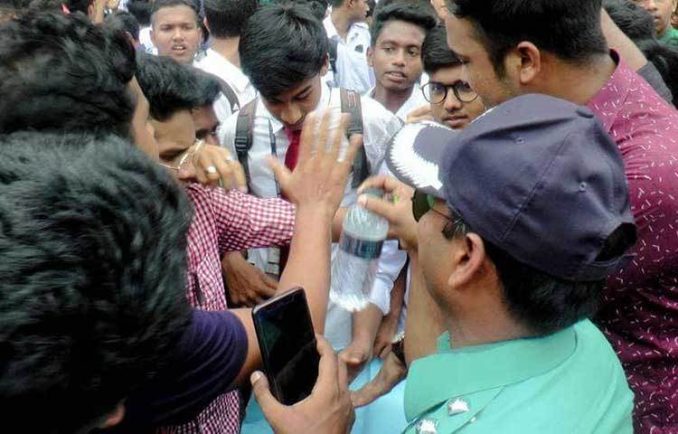 আন্দোলনরত ছাত্রদের পানি পান করাচ্ছেন এক পুলিশ সদস্য।