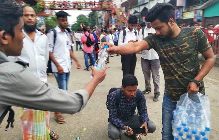 এক শিক্ষার্থী পানি নিচ্ছেন। রাজধানীর বিভিন্ন রাস্তায় দেখা গেছে অভিভাবকরা আন্দোলনরত শিক্ষার্থীদের মাঝে খাবার সরবরাহ করছে। ছবি : মাহবুব আলম