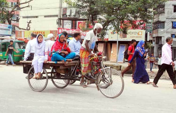 গাড়ি না পেয়ে ভ্যান গাড়িতে গন্তব্যে যাচ্ছে সাধারণ মানুষ। ছবি : বিপ্লব দিক্ষিৎ