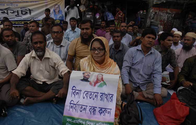 ‘বিনা বেতনে রাখার নির্যাতন বন্ধ করুর’, ‘কেউ খাবে, কেউ খাবে না; তা হবে না তা হবে না’, ‘এমপিও না হলে, ঘরে ফিরে যাবো না’, ‘এক দফা এক দাবি, এমপিও কবে দিবি’ -এমন নানা স্লোগান লেখা প্লাকার্ড, ফেস্টুন ও ব্যানার ঝুলিয়ে তারা বিক্ষোভ করে যাচ্ছেন শিক্ষক-কর্মচারীরা। ছবি : বিপ্লব দিক্ষিৎ