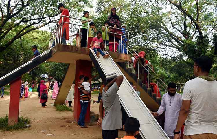 পিছলা খেতে ব্যস্ত শিশুরা। কোনো দুর্ঘটনা যেন না ঘটে সেজন্য অভিভাবকরা সতর্ক অবস্থায় দাঁড়িয়ে আছেন। ছবি : বিপ্লব দিক্ষিৎ