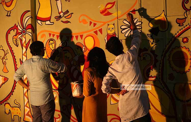 চারুকলার শিক্ষার্থীরা দল বেঁধে দেয়ালে বৈশাখী আলপনা আঁকছে। ছবি : মাহবুব আলম