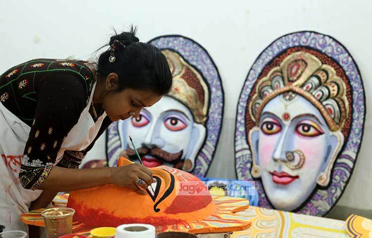 চারুকলার এক শিক্ষার্থী মুখোশে রংতুলি দিয়ে রাঙিয়ে তুলছে। ছবি : মাহবুব আলম