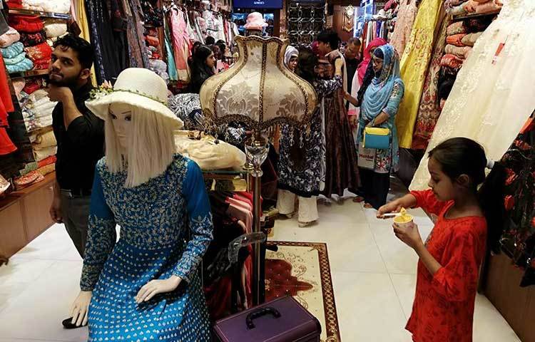 মা-বাবার সাথে ঈদের পোশাক কিনতে এসে খিদে পেয়েছে শিশুটির। তাই আইসক্রিম খাচ্ছে শিশুটি। ছবি : মাহবুব আলম