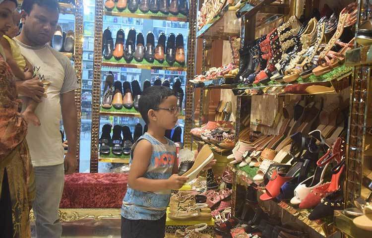 ঈদে নতুন পোশাকের সঙ্গে চাই নতুন জুতো। তাই পছন্দের জুতা খুঁজছে শিশুটি। ছবি : মাহবুব আলম