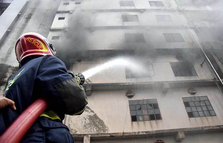 ফায়ার সার্ভিসের এক কর্মী আগুন নিভানোর চেষ্টা করছে। ছবি : মাহবুব আলম