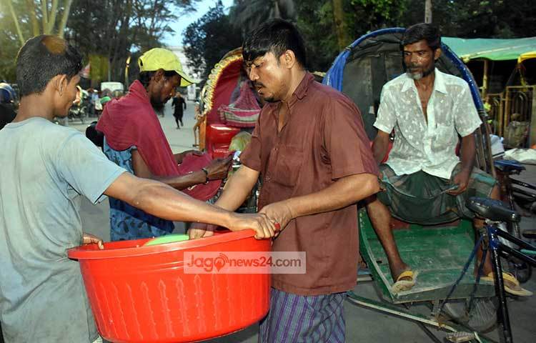রাস্তার পাশে রিকশাওয়ালদের মাঝে ইফতারি বিতরণ চলছে। ছবি : বিপ্লব দিক্ষিৎ