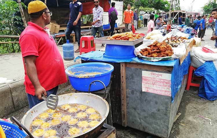 এ দোকানটিতে পিয়াজু বানানো হচ্ছে। রয়েছে ইফতারির অন্যান্য সামগ্রীও। ছবি : মাহবুব আলম