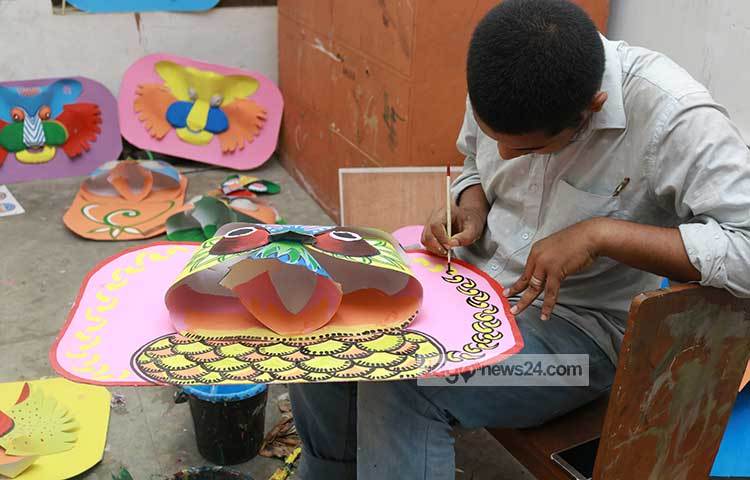 কাগজের তৈরি পেঁচায় রং করছেন একজন শিক্ষার্থী। ছবি : হাফিজুর রহমান