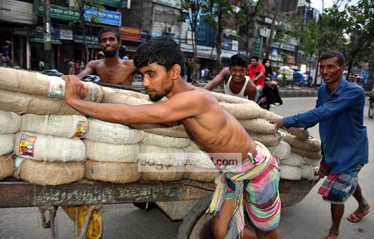 ঠেলা গাড়িতে মালামাল নিয়ে যাচ্ছেন শ্রমিকরা। ঘাম ঝরানো কাজ করেও আনন্দে থাকেন সারাদিন। ছবি : বিপ্লব দিক্ষিৎ